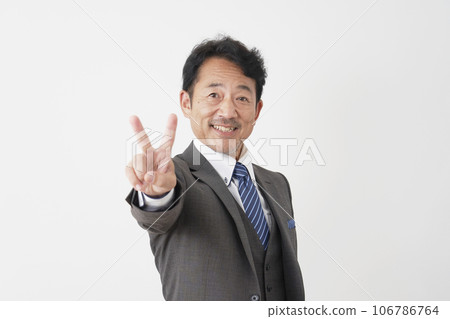 Middle-aged businessman giving peace sign, white background Middle-aged businessman giving peace sign, white background 106786764