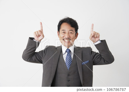 Middle-aged businessman pointing upwards, white background Middle-aged businessman pointing upwards, white background 106786787