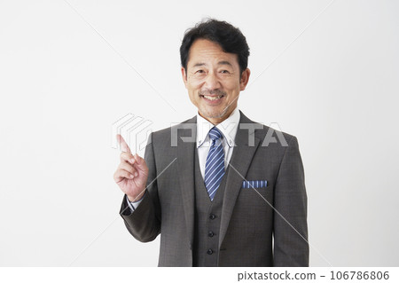 Middle-aged businessman pointing to the left, white background 106786806