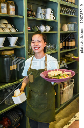 Vietnamese waitress serving belgian waffles with salad in a cafe 106787049