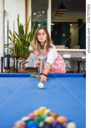 Young blond woman playing billiards in the backyard 106787068