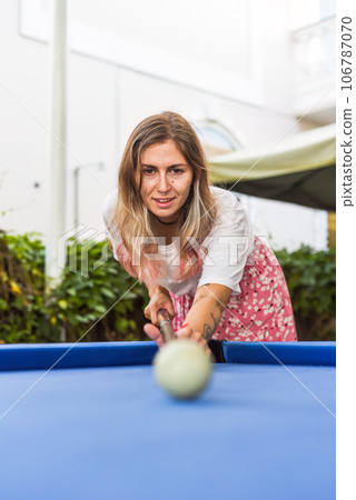 Young blond woman playing billiards in the backyard 106787070