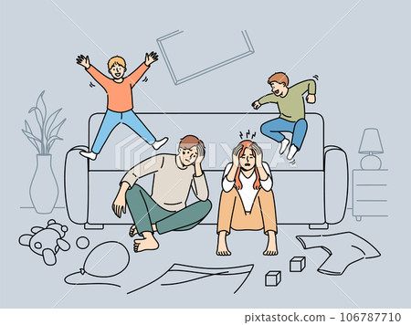 Tired parents sit on floor while mischievous children jump on sofa and throw things around house Tired parents sit on floor while mischievous children jump on sofa and throw things around house 106787710