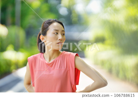 Young woman in sportswear stretching in the greenery Young woman in sportswear stretching in the greenery 106788615
