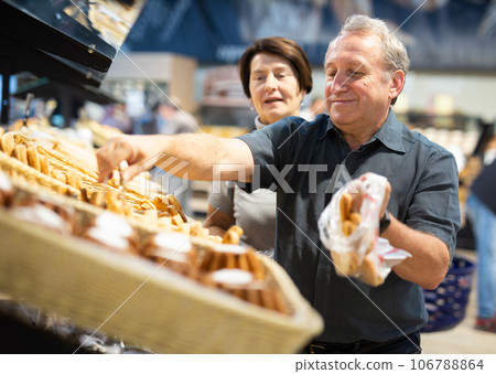 Couple chooses sweet puffs in bakery 106788864
