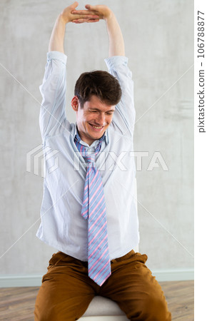Young guy office worker doing exercises on chair Young guy office worker doing exercises on chair 106788877