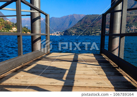 Wooden pier overlooking the Alps and Lake Como in Italy Wooden pier overlooking the Alps and Lake Como in Italy 106789164