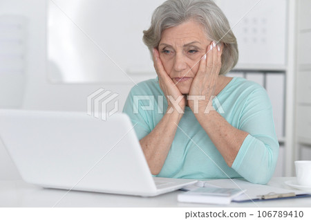 old woman with a laptop on a white background old woman with a laptop on a white background 106789410