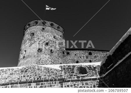 Round tower of Olavinlinna is under dark sky, black and white Round tower of Olavinlinna is under dark sky, black and white 106789507