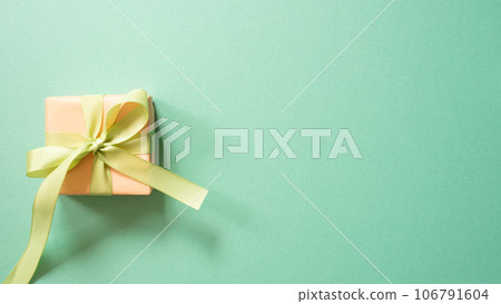 Coral gift box isolated on mint green background. top view, copy space 106791604