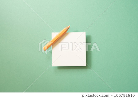 White memo paper, sticky note pad with colored pencil on green background. top view, copy space White memo paper, sticky note pad with colored pencil on green background. top view, copy space 106791610