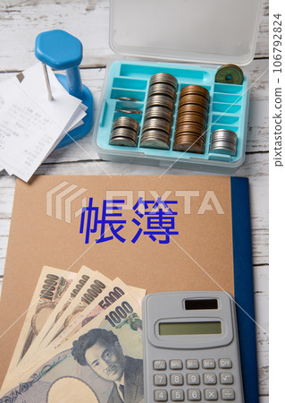Settlement image with ledger, calculator, cash, and slip holder Settlement image with ledger, calculator, cash, and slip holder 106792824