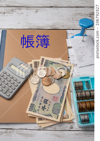 Settlement image with ledger, calculator, cash, and slip holder Settlement image with ledger, calculator, cash, and slip holder 106792827