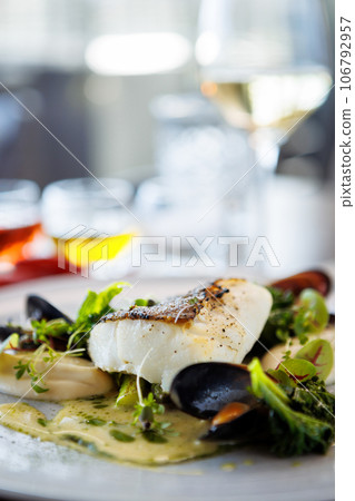 Cod fillet with cauliflower cream, asparagus, clam-wine sauce and mussles. Delicious seafood fish closeup served on a table for lunch in modern cuisine gourmet restaurant 106792957