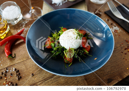 Burrata with paprika-truffle jam and cherry-cluster tomato salad. Delicious healthy Italian traditional food closeup served for lunch in modern gourmet cuisine restaurant 106792978