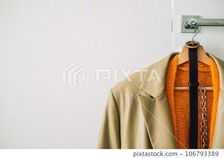 Capsule Wardrobe Autumn 2023, What To Wear This Fall. Autumn fall minimalist wardrobe with orange warm knitted sweater on wooden clothes hanger. Autumn capsule, warm fashion trends Capsule Wardrobe Autumn 2023, What To Wear This Fall. Autumn fall minimalist wardrobe with orange warm knitted sweater on wooden clothes hanger. Autumn capsule, warm fashion trends 106793389