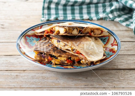 Mexican chicken quesadillas with cheese and peppers on wooden table. 106793526