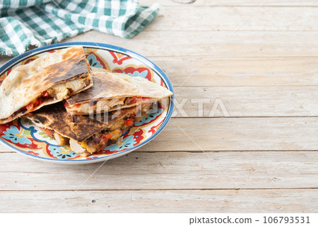 Mexican chicken quesadillas with cheese and peppers on wooden table. 106793531