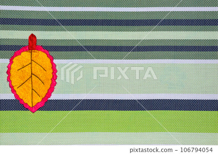 Yellow leaf handmade of fabric on striped background with copy space Yellow leaf handmade of fabric on striped background with copy space 106794054
