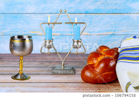 Traditional sabbath delight homemade challah bread, kosher wine, candles in jewish holiday observance 106794158