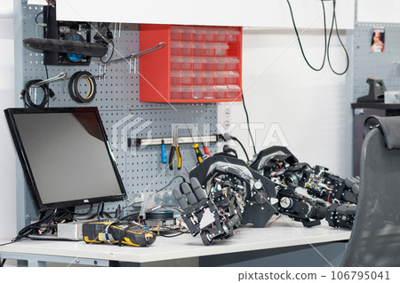workplace of the assembler of robots, mechanical hands lie on the desktop 106795041