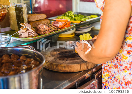 Vietnamese woman preparing ingredients for making traditional Banh Me on street food in Nha Trang 106795226