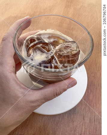hand holds glass of iced leccese coffee 106796784