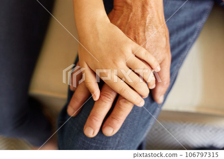 Closeup of hands of young child and old senior man, grandfather and granddaughter hands holding each other, family love and support. 106797315
