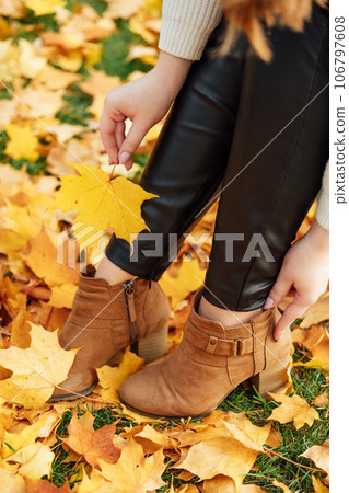 Autumn Shoes For Ladies, Styling Guide. How to prepare your shoes for autumn. Female legs in brown boots on autumn leaves background Autumn Shoes For Ladies, Styling Guide. How to prepare your shoes for autumn. Female legs in brown boots on autumn leaves background 106797608