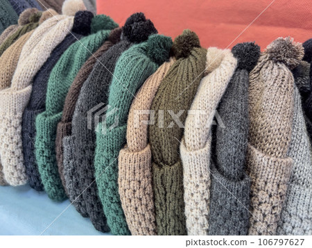 row of colorful knitted hats on shelf in store row of colorful knitted hats on shelf in store 106797627