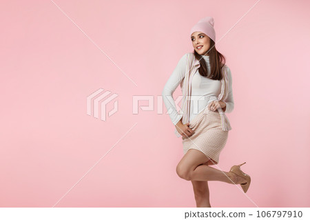 Happy playful young woman in pink hat, shirt and skirt 106797910