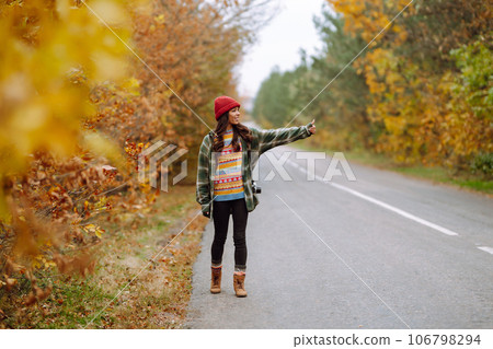 Woman- tourist taking pictures in autumn forest. Relaxation, tourism, nature, lifestyle concept. Woman- tourist taking pictures in autumn forest. Relaxation, tourism, nature, lifestyle concept. 106798294