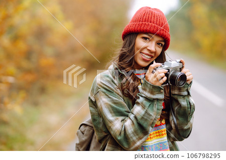 Beautiful young woman is photographed with retro camera. Rest, relaxation, travel, lifestyle concept Beautiful young woman is photographed with retro camera. Rest, relaxation, travel, lifestyle concept 106798295