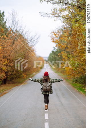 Woman- tourist taking pictures in autumn forest. Relaxation, tourism, nature, lifestyle concept. Woman- tourist taking pictures in autumn forest. Relaxation, tourism, nature, lifestyle concept. 106798339