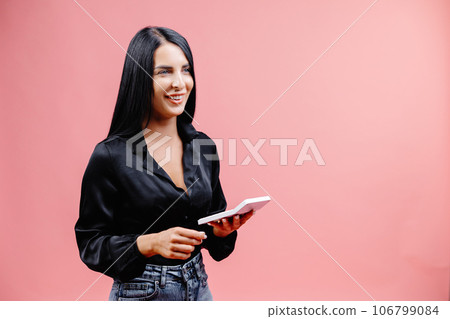 Young business woman in black shirt posing isolated on pink wall background in studio. Achievement career wealth business concept. Mock up copy space. Girl is holding calculator in hand 106799084