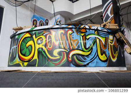 Deserted warehouse in state of ruins crumbling down, looking dirty and abandoned. Empty destroyed urban building with debris and graffiti spray paint artwork, broken bricks and chaos in ghetto. 106801299