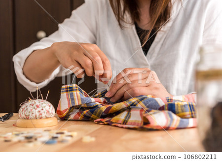 A woman sewing 106802211