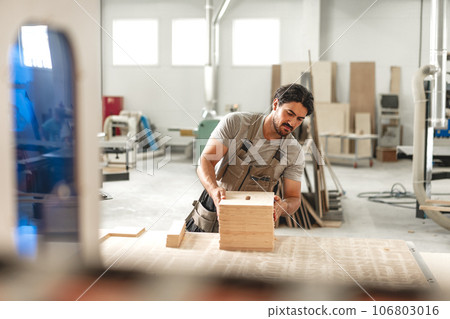 Young man doing woodwork in carpentry factory 106803016