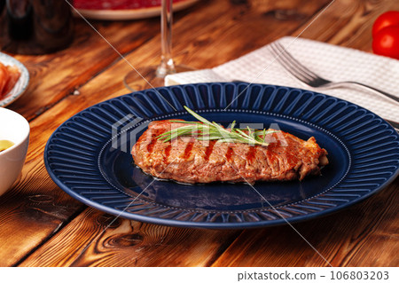 Grilled beef steak served on blue plate 106803203
