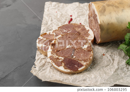 Liver sausage on parchment with parsley on gray background Liver sausage on parchment with parsley on gray background 106803295