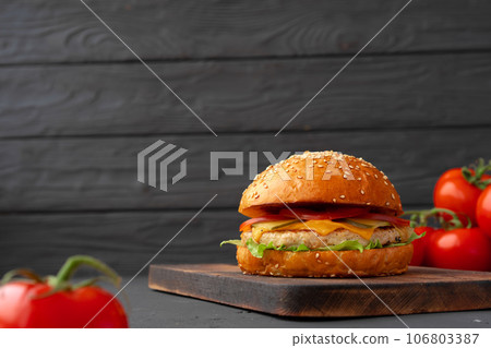 Close up of fresh tasty burger against black background Close up of fresh tasty burger against black background 106803387