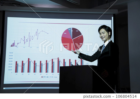 A young businessman giving a presentation using a projector at a meeting A young businessman giving a presentation using a projector at a meeting 106804514