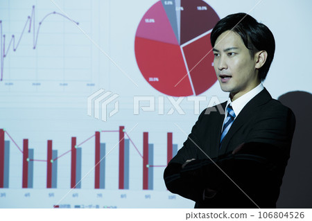 一位年輕商人在會議上使用投影儀進行演示 一位年輕商人在會議上使用投影儀進行演示 106804526