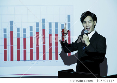 A young businessman giving a presentation using a projector at a meeting 106804547