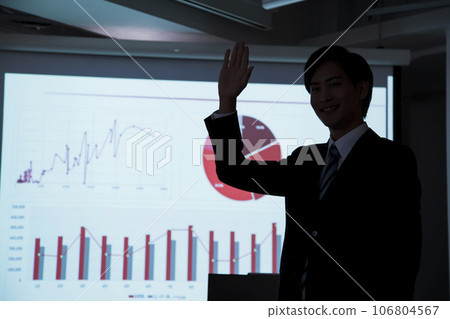 A young businessman giving a presentation using a projector at a meeting 106804567