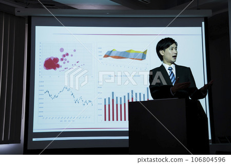 一位年輕商人在會議上使用投影儀進行演示 一位年輕商人在會議上使用投影儀進行演示 106804596