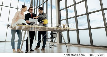 Engineer team is meeting to inspect the construction blueprint drawings, work plan and distribute work before starting the building 106805308