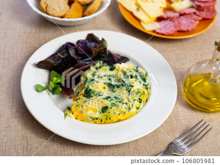 Appetizing breakfast omelette with spinach 106805981