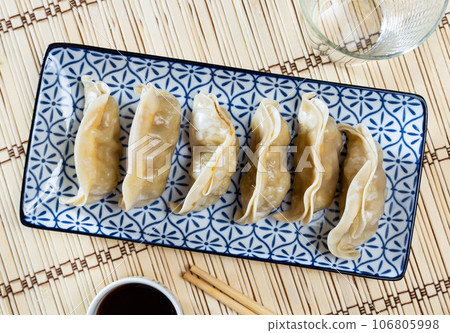 Steamed dumplings gyoza with meat filling served with sauce 106805998