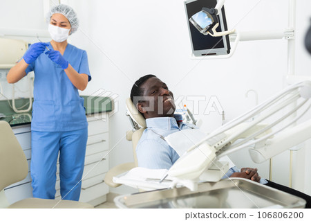 Smiling male patient sitting on dental chair and waiting for examination 106806200